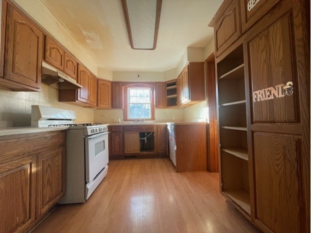 kitchen with gas range gas stove, light hardwood / wood-style floors, and decorative backsplash