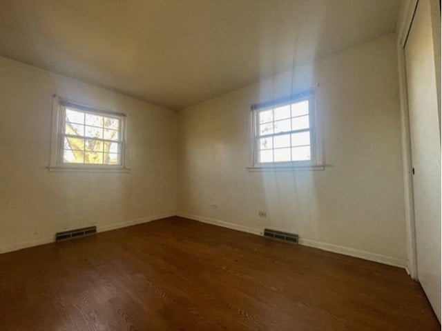 empty room with dark wood-type flooring