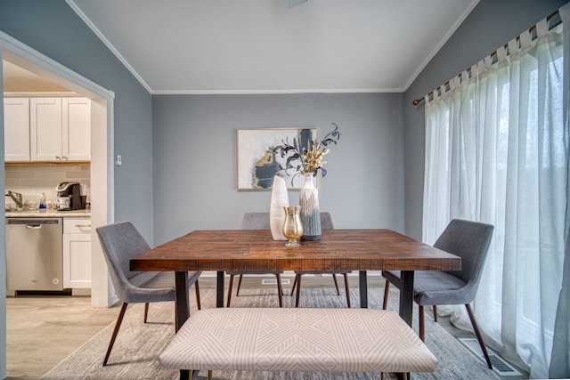 dining area featuring light wood-type flooring and crown molding