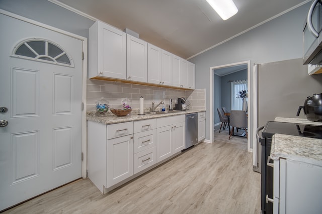 kitchen with appliances with stainless steel finishes, sink, light hardwood / wood-style floors, white cabinets, and lofted ceiling