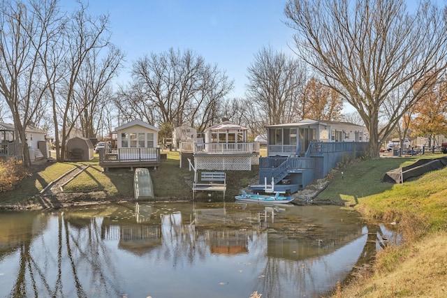 exterior space featuring a deck with water view, a sunroom, and a gazebo