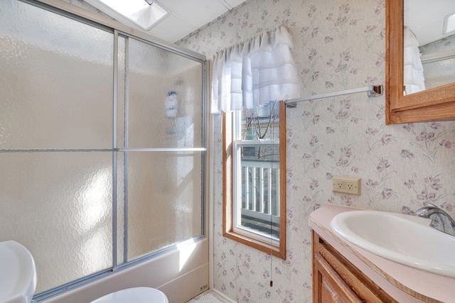 full bathroom with toilet, vanity, enclosed tub / shower combo, and a skylight