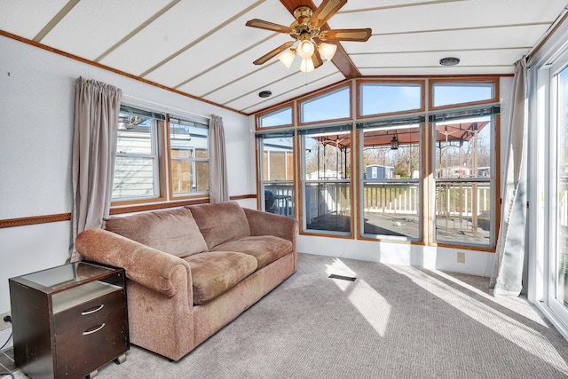 carpeted living room featuring lofted ceiling, ceiling fan, and a healthy amount of sunlight