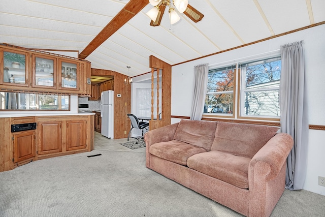 carpeted living room featuring wood walls, ceiling fan, and vaulted ceiling with beams