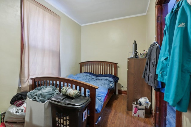 bedroom with crown molding and wood finished floors