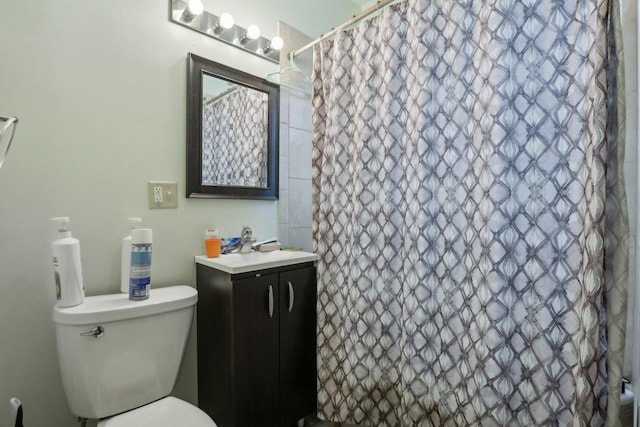 bathroom featuring curtained shower, toilet, and vanity