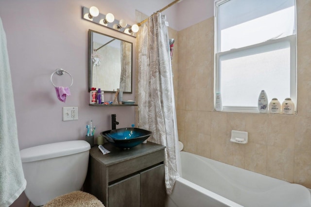 bathroom with toilet, shower / tub combo with curtain, and a sink