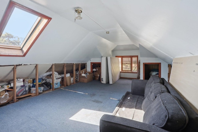 additional living space with vaulted ceiling with skylight and carpet floors