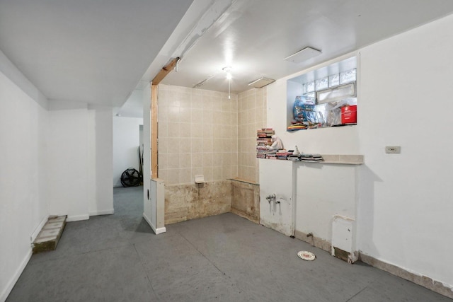 bathroom featuring baseboards and concrete flooring