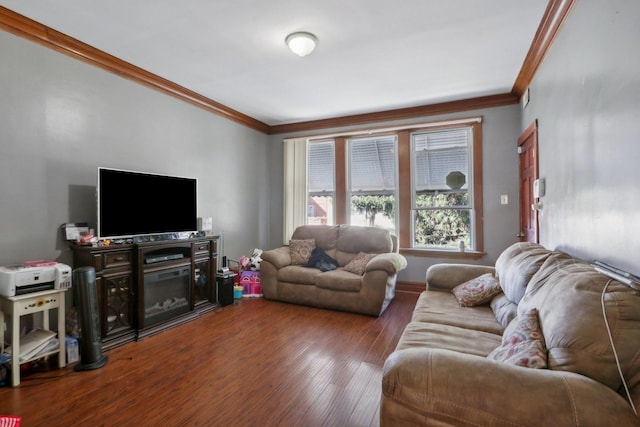 living area with baseboards, wood finished floors, and crown molding