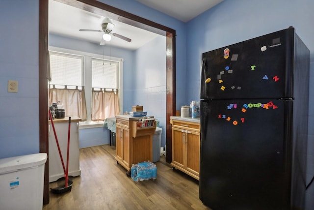 interior space featuring tile walls, wood finished floors, and ceiling fan