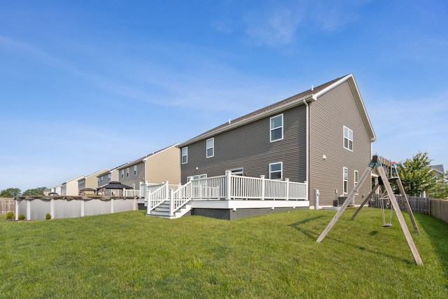 back of property with a playground, a lawn, and a deck