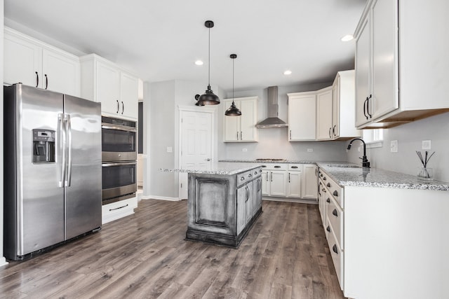 kitchen featuring stainless steel appliances, white cabinetry, sink, wall chimney exhaust hood, and a center island