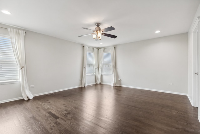 spare room with dark wood-type flooring and ceiling fan