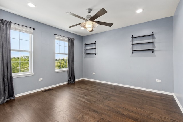 empty room with dark hardwood / wood-style flooring and ceiling fan