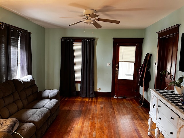 living room with dark wood-type flooring and ceiling fan