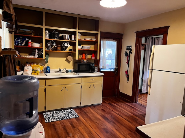 kitchen featuring dark hardwood / wood-style flooring, sink, and white fridge