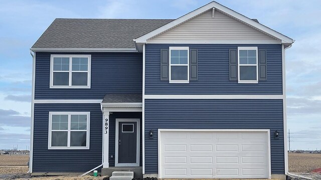 view of front of property featuring a garage and a front lawn