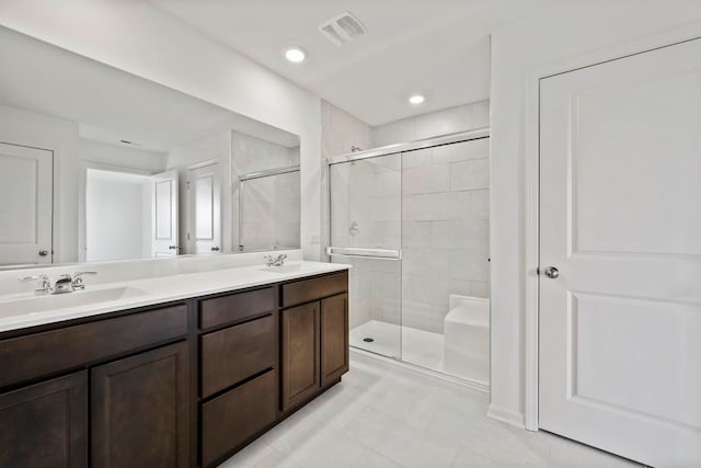 bathroom featuring tile patterned floors, vanity, and a shower with door