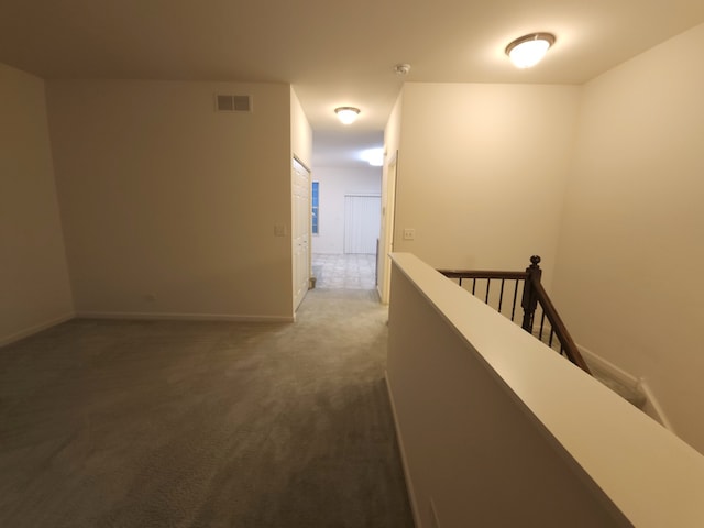 corridor featuring dark colored carpet