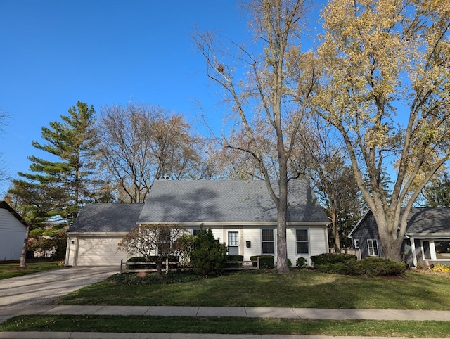 cape cod-style house with a garage, driveway, and a front lawn