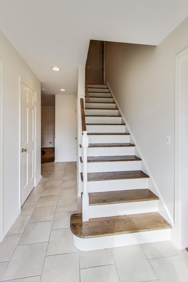 staircase with tile patterned flooring and recessed lighting