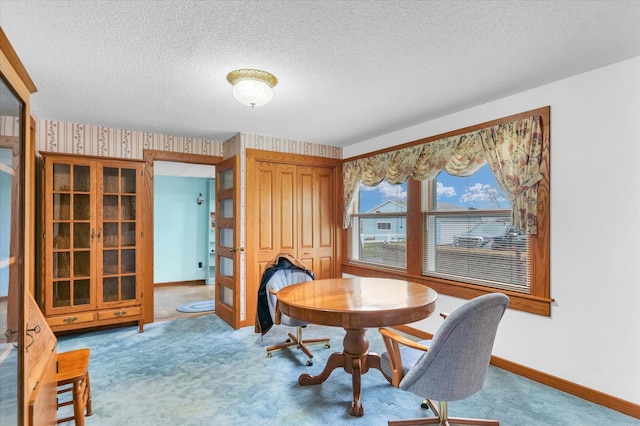 carpeted dining room featuring a textured ceiling