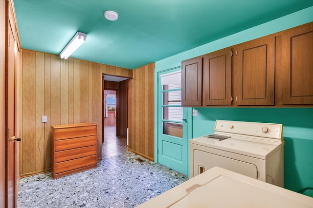 laundry area featuring wooden walls and cabinets