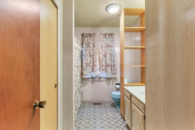 bathroom featuring tile patterned flooring, vanity, and toilet