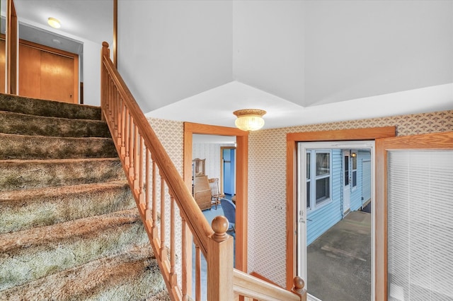 stairway featuring carpet flooring and lofted ceiling