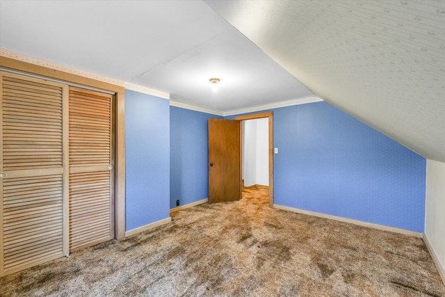 additional living space featuring carpet flooring and lofted ceiling