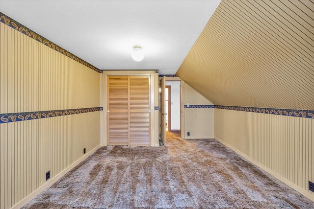 bonus room with vaulted ceiling and light colored carpet