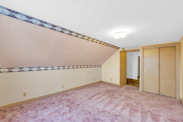 additional living space with light colored carpet and vaulted ceiling