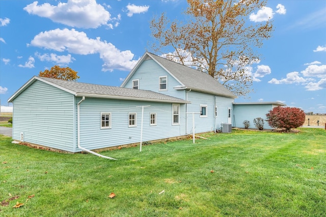 back of property featuring central AC and a lawn