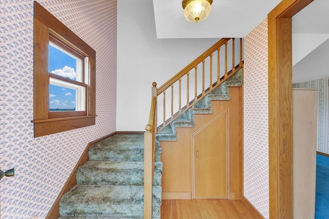 stairs with vaulted ceiling and wood-type flooring