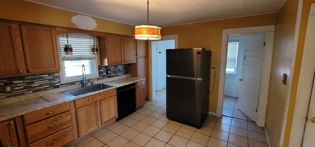 kitchen with dishwasher, backsplash, hanging light fixtures, sink, and stainless steel refrigerator