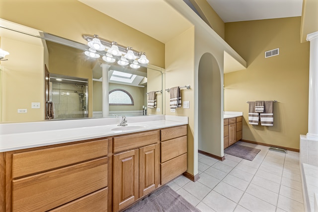 bathroom featuring tile patterned flooring, vanity, vaulted ceiling, and walk in shower