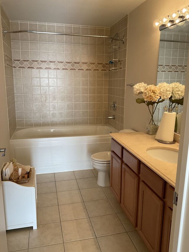 full bathroom featuring toilet, tile patterned flooring, vanity, and tiled shower / bath