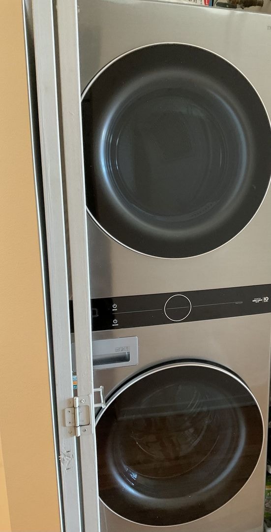 clothes washing area featuring stacked washer and dryer