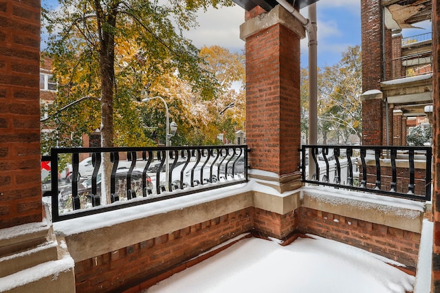 view of snow covered back of property