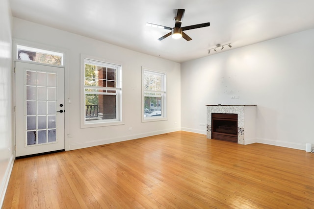 unfurnished living room featuring ceiling fan and light hardwood / wood-style floors