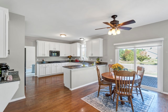 kitchen featuring gas stovetop, dark hardwood / wood-style floors, sink, white cabinets, and ceiling fan