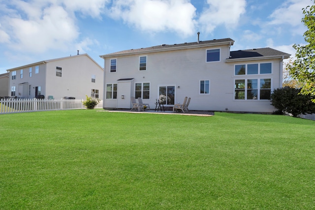 back of house with a lawn and a patio