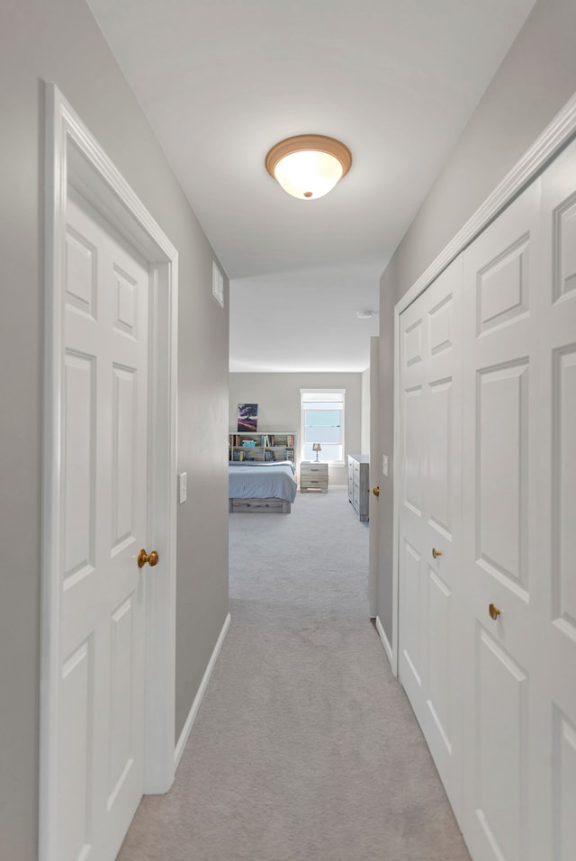 hallway featuring light colored carpet