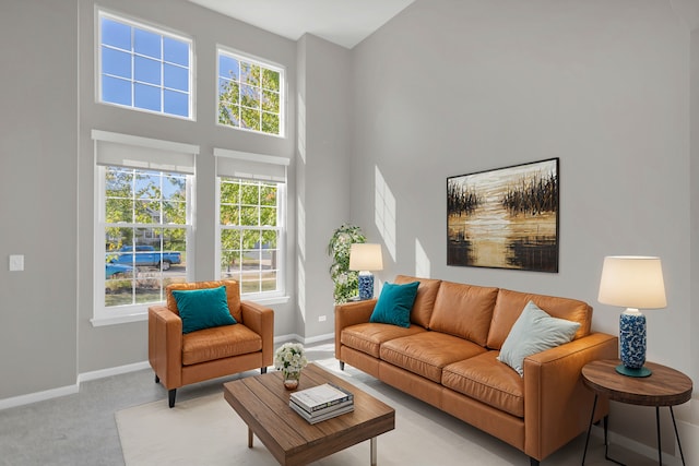 living room featuring a towering ceiling and light carpet