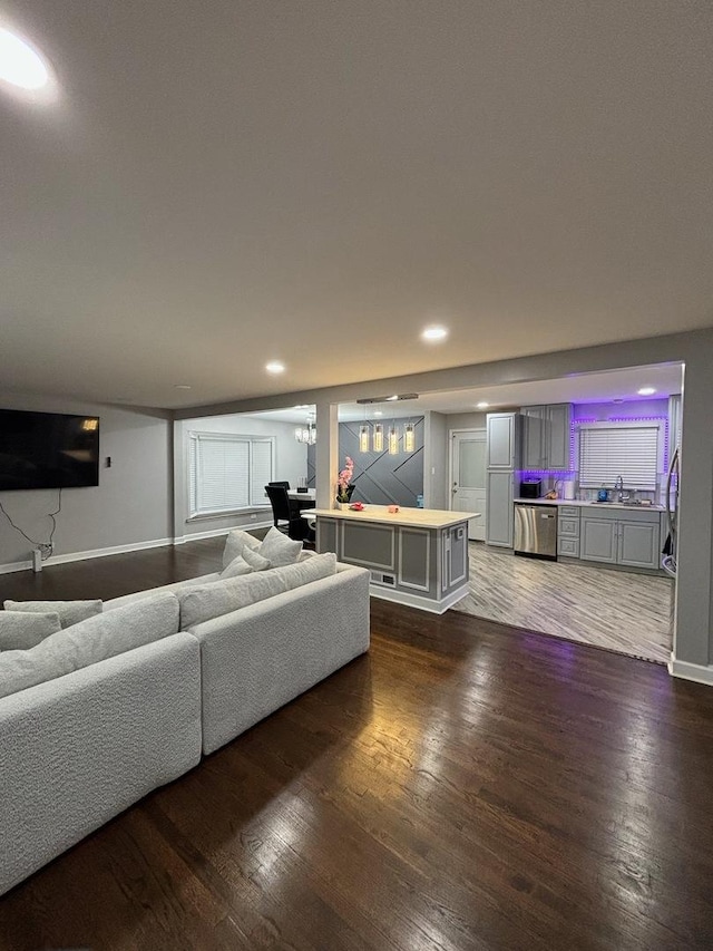 living room featuring sink and dark hardwood / wood-style floors