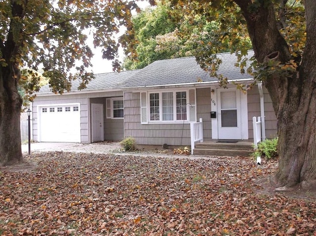 single story home featuring an attached garage and roof with shingles