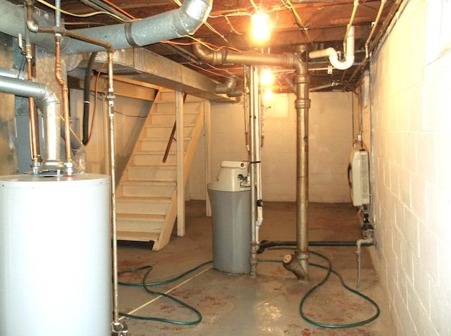 unfinished basement featuring stairs and gas water heater