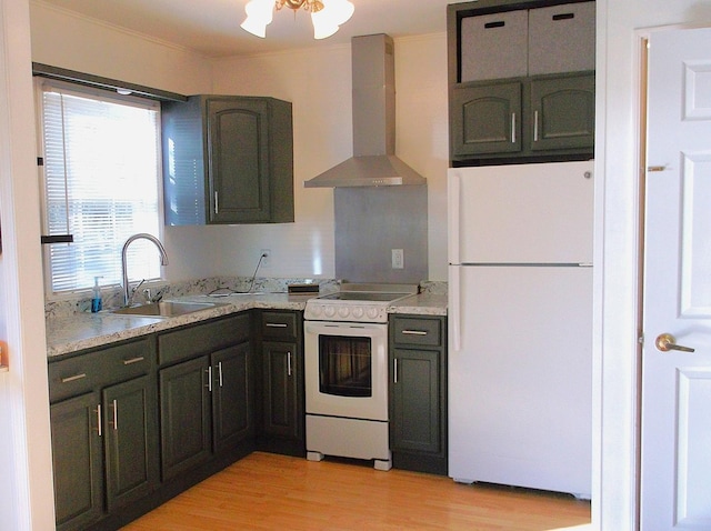 kitchen with light wood finished floors, light countertops, a sink, white appliances, and wall chimney exhaust hood