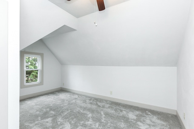 additional living space featuring lofted ceiling, light carpet, and ceiling fan